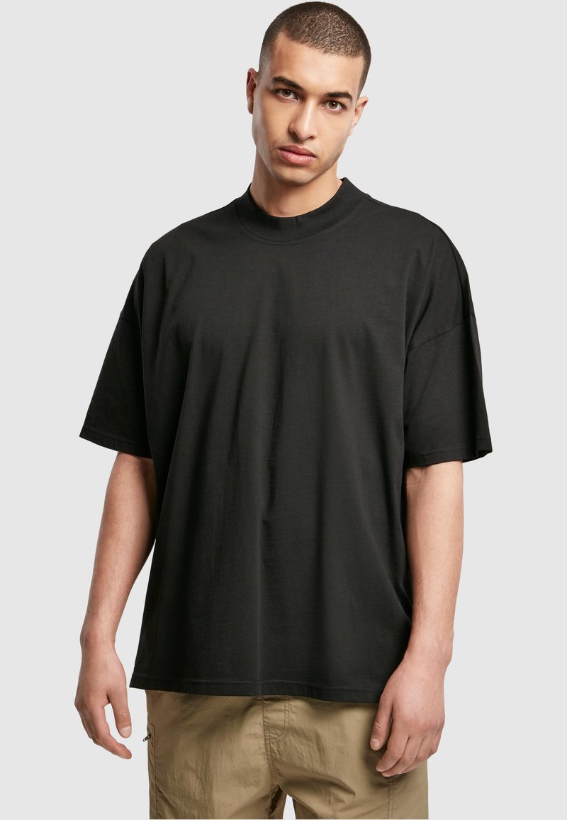T-shirt noir à manches courtes, de coupe ample, avec un col rond. Fabriqué en coton doux, il présente un design minimaliste avec une texture lisse.