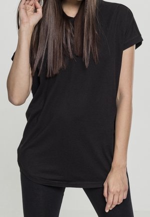 T-shirt nera a maniche corte con vestibilità comoda e orlo arrotondato, realizzata in morbido cotone con una texture liscia.
