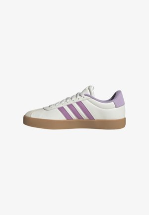 Zapatilla deportiva blanca con tres rayas moradas, suela de goma marrón, parte superior de cuero texturizado y acento en el talón de color morado claro.