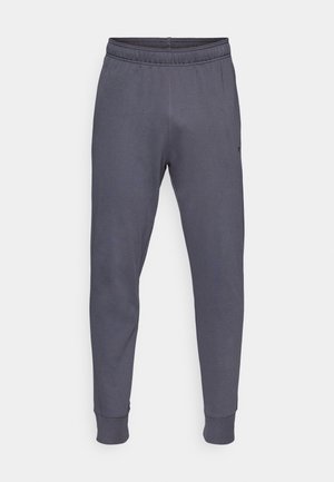 Pantalon de survêtement gris avec une taille élastique, des jambes fuselées et des poignets côtelés. Fabriqué en tissu doux et extensible. Petit logo sur le côté.
