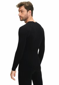 Zwarte thermoshirt met lange mouwen, gemaakt van ribfabric, met een getailleerd ontwerp, tekstuurlijke schouders en een ronde hals.