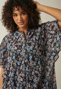 Bluse mit floralem Muster, schwarzer Hintergrund mit blauen, rosa und cremefarbenen Blumen. Mit Knopfverschluss und lockeren, fließenden Ärmeln.