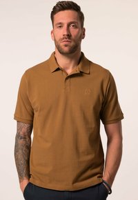Brązowa koszulka polo wykonana z teksturowanej tkaniny z kołnierzykiem, z małym haftowanym logo na piersi i krótkimi rękawami.