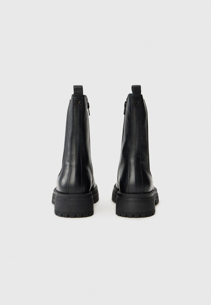 Schwarze Lederknöchelstiefel mit glatter Oberfläche, ausgestattet mit einer gestapelten Sohle und einem Reißverschluss, verziert mit einem Logoakzent an der Ferse.