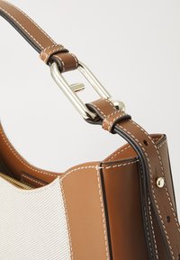 Borsa a tracolla in pelle marrone con tessuto intrecciato color beige. Caratterizzata da accessori in oro, dettagli cuciti e una robusta tracolla.