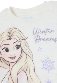 Weißer Fleece-Sweatshirt mit einem Cartoon-Charakter mit hellblondem Haar. "Winterträume" ist in lila mit Schneeflocken-Akzenten gestickt.
