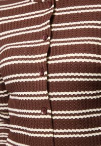 Cárdigan a rayas marrón y blanco con un tejido texturizado, que cuenta con botones redondeados y una forma ajustada, destacando un diseño casual.