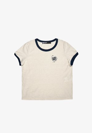 Kreemja ja tumesinise triibuga lühikeste varrukatega T-särk, tumesinise krae ja mansettidega, vasakul rinnal väike südametukujuline logo, mis kannab nime "Bimba Y Lola."