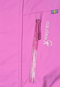 Rosa jacka med en slät yta, med en ficka med dragkedja, logotryck och en liten svensk flagga som accent. Enkel, funktionell design.