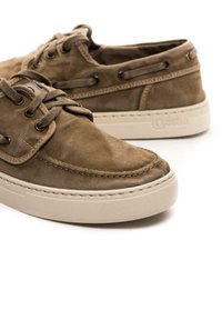 Scarpe in tela marrone con punta tonda, dettagli cuciti e suola in gomma beige. Due fori per lacci, con superficie testurizzata.