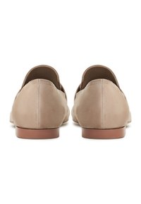 Paire de chaussures plates en daim beige avec petits talons, vue de dos sur fond blanc.