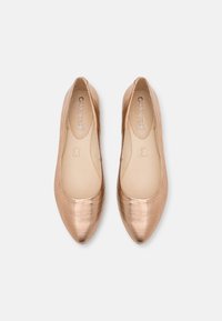 Růžově zlaté ploché boty s špičatou špičkou, hladkým metalickým povrchem a měkkou stélkou, s jemným logem na vnitřní podšívce.