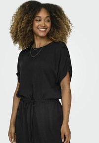 Robe noire à manches courtes, avec une coupe décontractée et une taille à liens. Tissu texturé avec un drapé doux. Design minimaliste, adapté pour un usage décontracté.