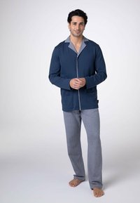 Set di pigiama blu navy con top con bottoni, colletto grigio, maniche lunghe e due tasche frontali, abbinato a pantaloni grigi. Vestibilità regolabile.