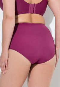 Mutande viola a vita alta realizzate in tessuto liscio, caratterizzate da un design senza cuciture e bordi cuciti, mostrate da dietro con dettagli minimi.
