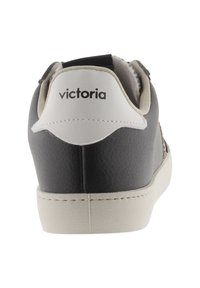 Svart och vit sneaker med strukturerad läderöverdela, ljusfärgad sula och "victoria"-logotyp på hälen. Klassisk design, låg modell.