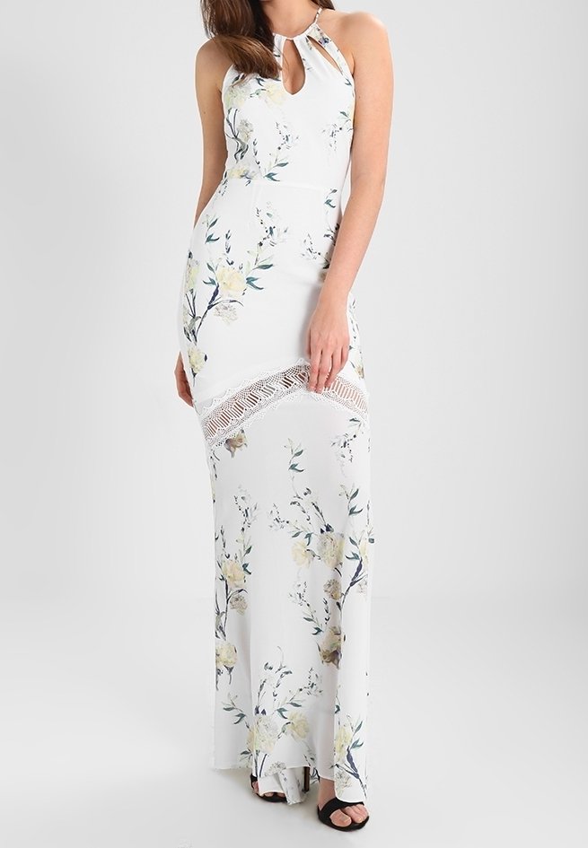Vestito lungo floreale bianco con motivi gialli e blu. Presenta un collo a catena e un accento in pizzo vicino all'orlo. Realizzato in tessuto leggero.
