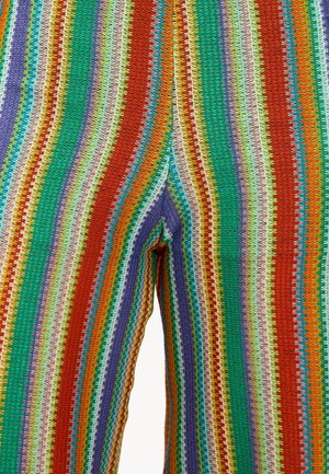 Pantalons rayés multicolores présentant des motifs vibrants de vert, rouge, violet et orange, fabriqués en matériau texturé et extensible avec un design en zigzag.