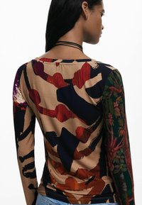 Langærmet top med et tætsiddende design, der har en blanding af abstrakte mønstre i brun, rød og mørkeblå på et glat stof.
