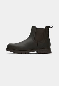 Botine din piele maro până la gleznă cu panouri elastice pe laterale, un tab pentru tragere și talpă din cauciuc texturat cu un model de crampoane pentru aderență.