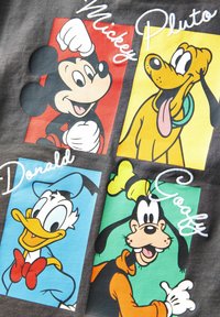 Šedá košile se čtyřmi ilustracemi postav: Mickey Mouse (červený), Pluto (žlutý), Donald Duck (modrý) a Goofy (zelený) s bílým textem.