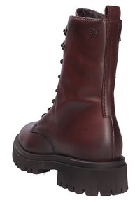 Brown leather ankle boot with a rounded toe, lace-up front, and thick rubber sole featuring a textured pattern. Plain back with logo detail.