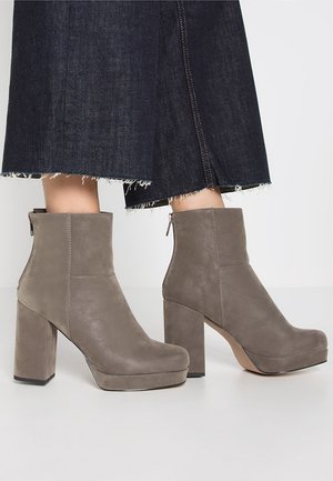 Szare skórzane botki za kostkę z blokowym obcasem i platformą, z zamkiem błyskawicznym, gładką fakturą i minimalistycznym designem.