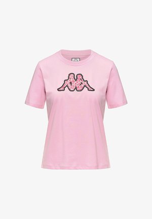 T-shirt rose clair à manches courtes avec un col rond, arborant un motif central représentant deux silhouettes assises avec un imprimé léopard rose.