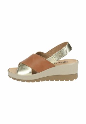 Sandale avec un design de lanière croisée en cuir brun et doré métallique. Dispose d'un semelle compensée avec une finition beige clair texturée.