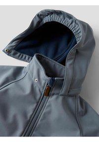 Veste grise à capuche avec doublure en polaire bleue, fermeture éclair à l'avant et détails à boutons-pression sur le col et le bord de la capuche.