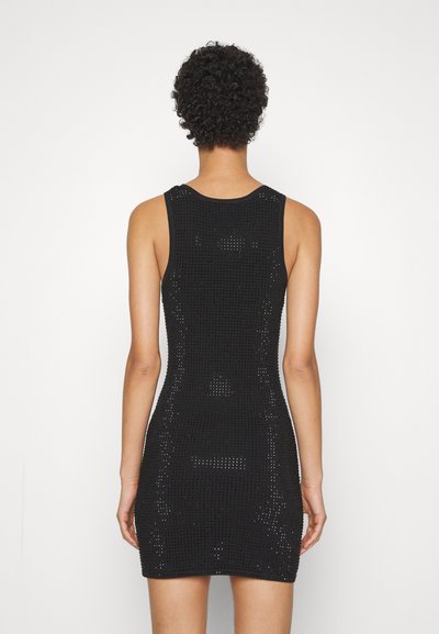 Robe noire sans manches au design ajusté, avec un motif en tricot texturé et une élasticité minimale. Encolure ronde et coutures d'épaules visibles.