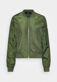 Zielona kurtka bomberka z błyszczącego satyny. Posiada zapięcie na zamek z przodu, ściągacze na rękawach oraz boczne kieszenie zapinane na zatrzaski. Gładka faktura.