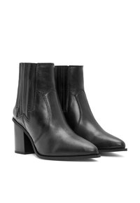 Botas de tobillo de cuero negro con puntera afilada, tacón apilado, paneles laterales elásticos y detalles de costura. Textura suave, diseño minimalista.