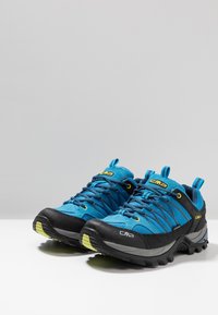 Niebieskie i czarne buty outdoorowe z teksturowanym materiałem wierzchnim, wzmocnionym czubkiem, żółtymi akcentami oraz wytrzymałą podeszwą zapewniającą dobrą przyczepność.