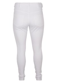 Bijele skinny traperice s glatkom teksturom, s visokim strukom i dvije stražnje džepove, dizajnirane za uski kroj.