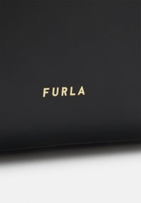 Černá kožená peněženka s zlatým značením "FURLA". Hladký povrch, obdélníkový tvar, minimalistický design, bez viditelných vzorů nebo kovových detailů.