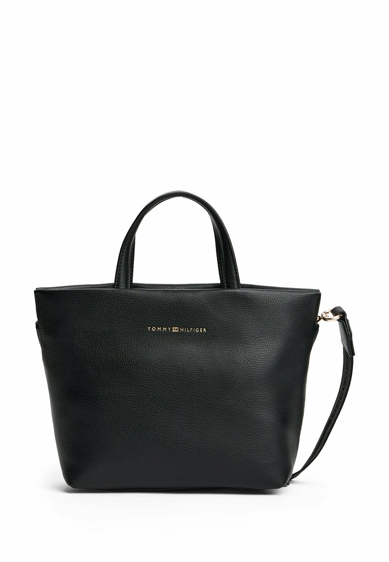 Sac fourre-tout en cuir noir avec deux poignées courtes, une bandoulière amovible et un logo en relief doré à l'avant. Surface texturée.