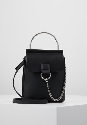 Schwarze rechteckige Handtasche mit Klappverschluss, silbernem Metallgriff, dekorativer Kette und schmalem Schulterriemen auf weißem Untergrund.