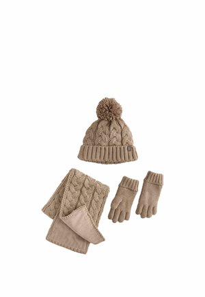 Beige strikket vintersæt med pompom-hue, kabelstrikket halsedisse foret med fleece og matchende handsker på hvid baggrund.