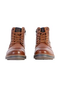 Bottes chelsea en cuir marron avec des bouts ronds, dotées de lacets, d'une fermeture éclair sur le côté, et d'accents bleu marine contrastants sur la languette.
