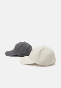 Due cappelli: uno grigio e uno beige. Il cappello grigio ha del testo bianco; il cappello beige presenta del testo rosso. Entrambi sono in cotone, con visiere curve e fori di ventilazione.