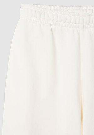 Kremowe dresy z elastycznym paskiem w talii, gładką fakturą i prostymi nogawkami, idealne do noszenia na co dzień.