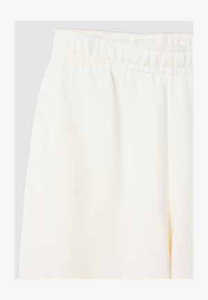 Kremowe dresy z elastycznym paskiem w talii, gładką fakturą i prostymi nogawkami, idealne do noszenia na co dzień.