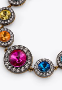 Collana colorata con pietre di vetro circolari in rosa, blu, giallo, arancione e verde, inserite in un telaio metallico dorato con dettagli trasparenti.