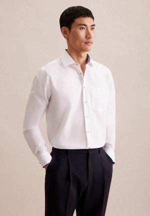 Witte lange mouwen overhemd met knoopsluiting en een enkele borstzak, met een gemusterde kraagaccent, gecombineerd met donkere broek.