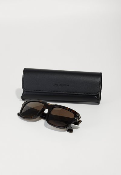 Ochelari de soare cu carapace de broască țestoasă, cu lentile de culoare maro închis și accesorii din argint, asortați cu un etui din piele neagră cu branding embossat.