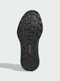 Sole topánky s hlbokými vzormi a vyrazeným logom "Continental" v oranžovej farbe na čiernej gumovej podrážke.