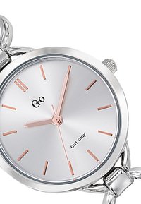 Montre argentée avec un cadran rond, dotée d'un cadran en argent brossé, d'aiguilles en or rose et d'un bracelet en maillons argentés. Inscription "Go Girl Only" affichée.