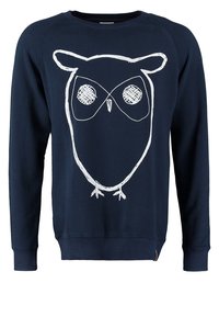 Sweat bleu marine avec un simple dessin au trait blanc d'une chouette sur le devant, avec de grands yeux et de petits pieds.