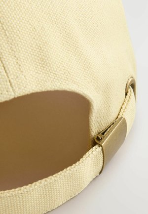 Gelbe Canvas-Kappe mit strukturierter Oberfläche, runder Form und einem Metallverschluss zur Anpassung auf der Rückseite.